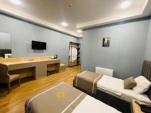 祖格迪迪DADIANI Inn的配有一张床、一张桌子和一张桌子的酒店客房