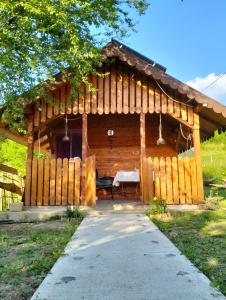SălătrucelCabana din Livada, Călimănești的小木屋,设有草地围栏
