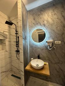 布拉索夫Stay Inn Central Brasov Apartments的一间带水槽和镜子的浴室