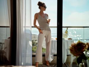 梅尔诺Baltivia Sea Resort的站在窗前的女装白跳跃