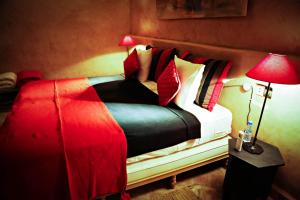 塔鲁丹特Le moulin的一间卧室配有红色和白色枕头的床