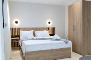 米里纳RAFKON Luxury Apartments - Myrina的一间卧室配有一张大床和木制床头板