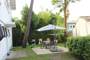 龙斯莱班Appartement entièrement rénové à Ronce Les Bains avec jardin的一个带桌子和遮阳伞的庭院