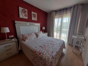 圣佩德罗-德尔皮纳塔尔Habitación bonita的一间卧室设有一张红色墙壁和窗户的床