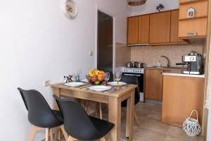 马塔拉Stelios Apartment的一个带木桌和椅子的小厨房