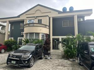 拉各斯Primal Msquare Apartment Ikoyi的停在房子前面的一辆黑色汽车