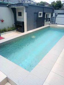 拉各斯Primal Msquare Apartment Ikoyi的大楼前的蓝色海水游泳池
