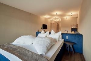 韦尔图尔诺Vinumhotel Feldthurnerhof的卧室配有带白色枕头的大床