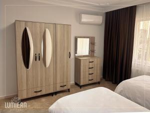 NilüferLumiera Suites Hotel的一间卧室设有大型木制橱柜和镜子