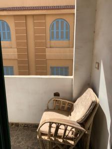 法尤姆Azzam Guest House 2 families only的阳台的椅子,与大楼相连