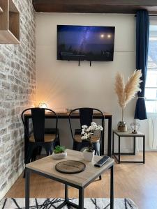 莫雷卢安河Escapade Moretaine - Cosy Studio的客厅配有桌子,墙上配有电视