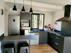 圣弗洛朗Jardin et 2 chambres centre St Florent的厨房配有黑白柜台和电器