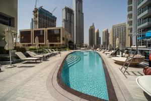 迪拜Spectacular Views of Burj & Fountain - 2 BR的一座带躺椅的大型游泳池,位于大楼内