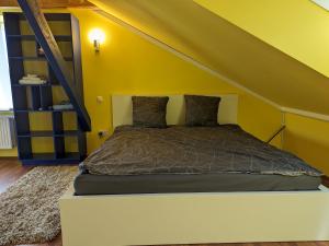 AlbersdorfAnton's bunte Welt (100 m², Parkplatz, Garten und viel mehr)的黄色墙的房间里一张床位