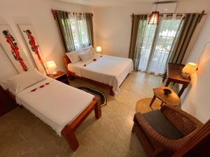 吉汶瓦Stone Resort的酒店客房,配有两张床和椅子