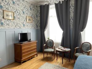 滨海布洛涅La Boulonnaise的一间卧室配有电视、梳妆台和窗户。