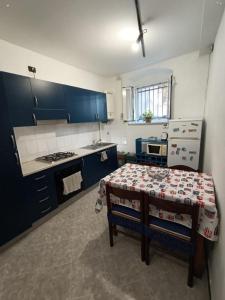 热那亚Dai Pescatori Nervi的厨房配有蓝色橱柜和桌子