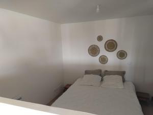 CombaillauxStudio secteur pic Saint Loup的卧室配有一张床,墙上挂着三个盘子