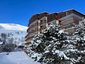 莱德萨阿尔卑斯4 pers, pied des pistes, WIFI, Netflix, Lave-vaisselle的前面有一棵雪覆盖的树