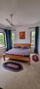 布韦朱Maracuja villa Zanzibar的一间卧室设有一张床和两个窗户。