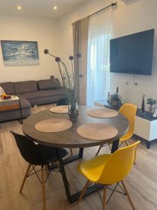 木洛希尼Apartman Sea story Mali Lošinj的客厅配有桌子和黄色椅子