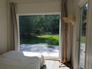 Västra TorupThe Black and White cabin with Spa bath的一间卧室设有一张床和一个大型滑动玻璃门