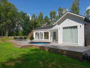 Västra TorupThe Black and White cabin with Spa bath的一座带甲板和游泳池的房子