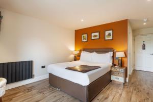 BolventorThe Jamaica Inn, Bodmin, Cornwall的一间卧室配有一张带橙色墙壁的大床