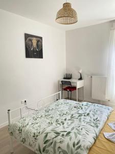 邦迪Bel appart T2 idéalement situé的白色卧室配有床和书桌