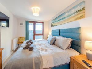 伍拉科姆Beachbreak - Uk42996的一间卧室配有一张大床和蓝色床头板