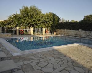 达西亚Spiros Athinaios Apartment's的一个带围栏的院子内的游泳池