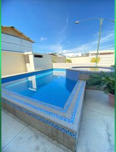 圣克莱门特Departamento amoblado con piscina en San Clemente的周围设有蓝色瓷砖的游泳池