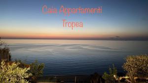 特罗佩阿Caia Appartamenti Tropea的日落时分海景公寓 - 带热带“咖啡”