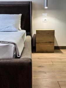都拉斯ALEXANDER Rooms & Apartments的一张铺有木地板的黑色床头床