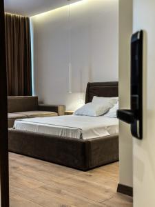 都拉斯ALEXANDER Rooms & Apartments的卧室配有一张床和电视,位于地面楼层