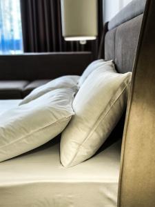 都拉斯ALEXANDER Rooms & Apartments的一组枕头坐在床上