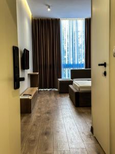 都拉斯ALEXANDER Rooms & Apartments的客房设有床、沙发和窗户。