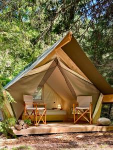 OplotnicaGlamping Tent Water Village Rogla的帐篷配有两把椅子和一张床