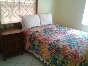 维约堡奥普克天堂酒店的一间卧室配有一张带五颜六色的被子和一张桌子的床