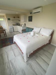 卡斯特里Memwa Villas的一间卧室配有一张带粉红色鲜花的大床