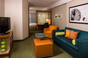 皇后区万豪纽约拉瓜迪亚机场春季山丘套房的一间配备有沙发及电视的酒店客房