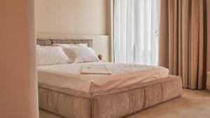 伏罗拉Azar Luxury Suites的卧室内的一张床铺,设有大窗户