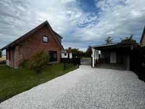 HolebyCozy Holeby House Close to Puttgarden & Femern的砖屋,车道通往车库