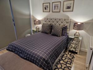 滨海利leigh Penthouse Apartment的一间卧室配有一张带 ⁇ 子毯子和两盏灯的床。