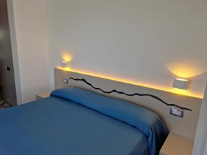 伊斯基亚达玛丽亚酒店的一间卧室配有蓝色的床和两盏灯