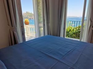 伊斯基亚达玛丽亚酒店的一间卧室设有蓝色的床和大窗户