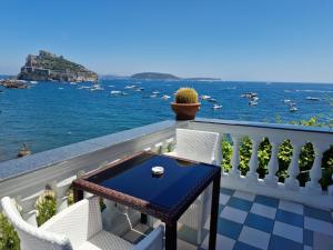 伊斯基亚达玛丽亚酒店的一个带桌椅的海景阳台