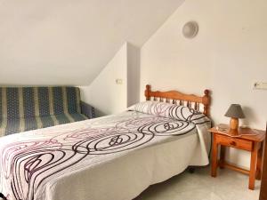 艾利亚德亚罗萨金雷伊酒店的一间卧室配有一张床和一张带台灯的桌子