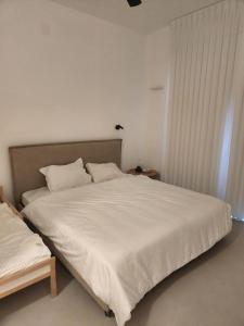 Temarahסוויטה פרטית ברמת צבי的一间卧室配有一张带白色床单的大床