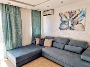 洛泽内茨Oazis resort lux vip apartament的客厅配有沙发和墙上的绘画